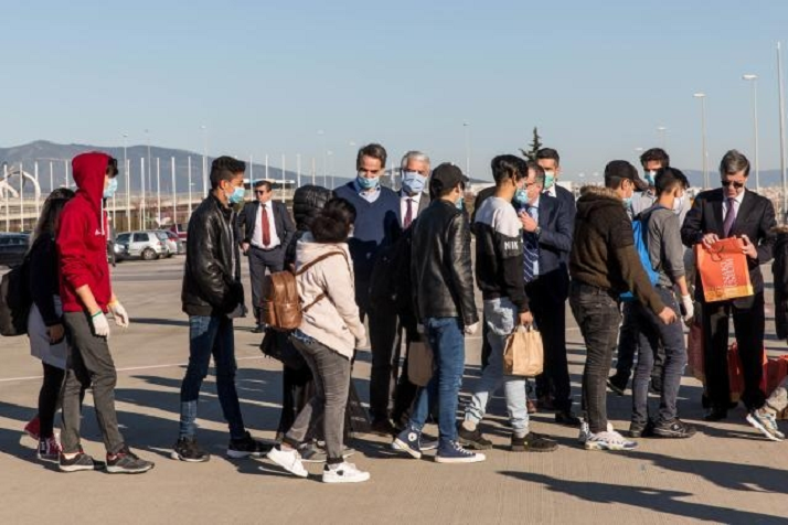 migranti in fila verso un aereo